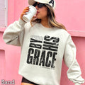 By His Grace Women’s Christian Graphic Sweatshirt: Sand
